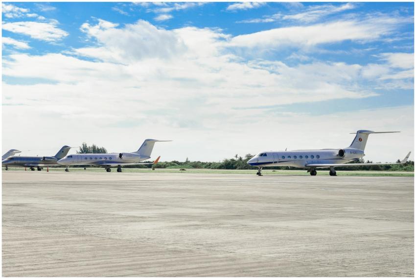 Private jets parked on an airport runway under a c