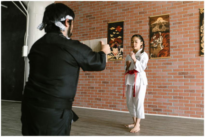 A young girl prepares to break a board in a dojo,