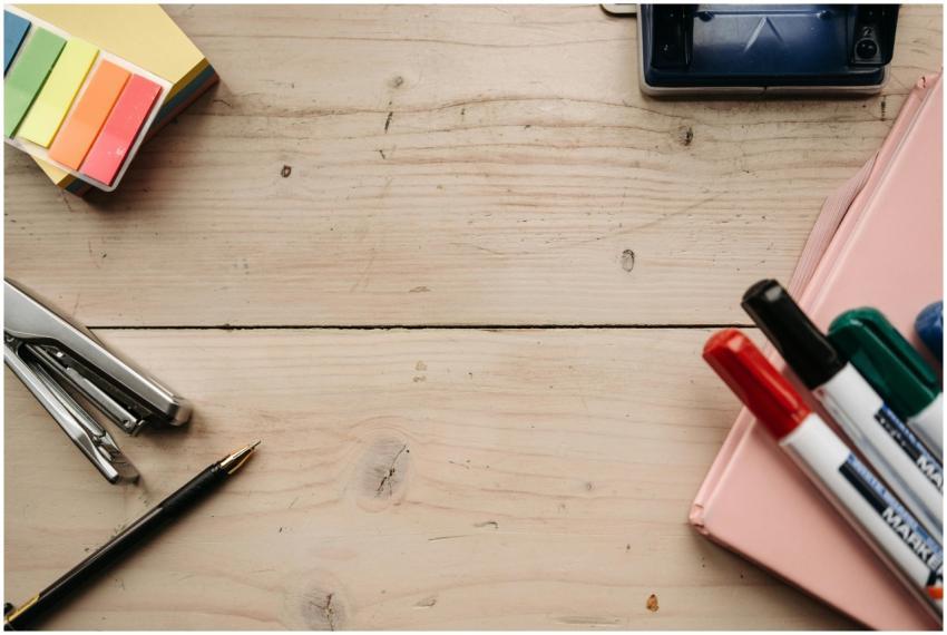 Top view of office supplies including markers, sta