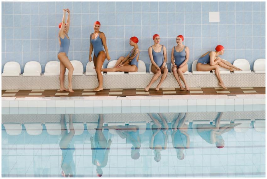 Women synchronized swimmers in swimsuits and caps