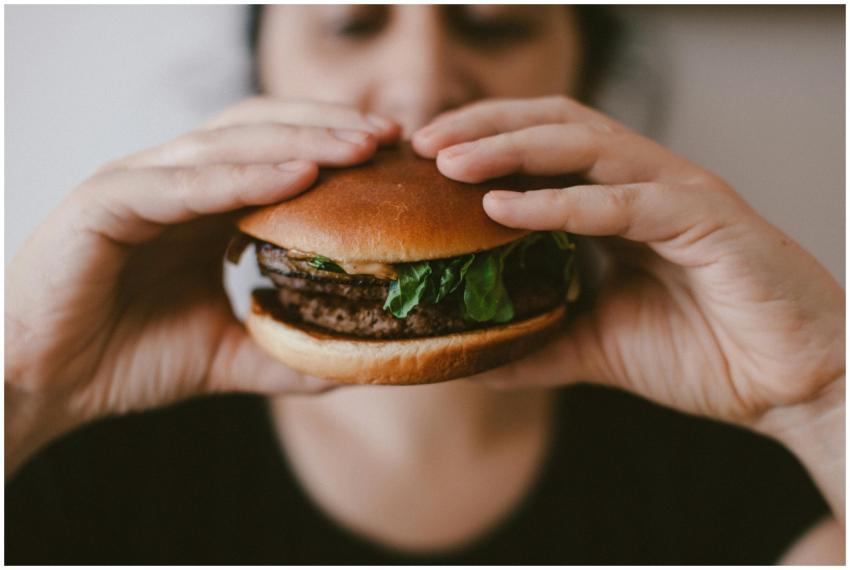 Delicious beef burger with fresh lettuce held by a