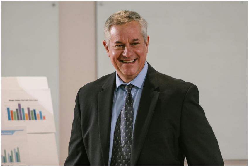 Smiling businessman in a corporate setting with ch