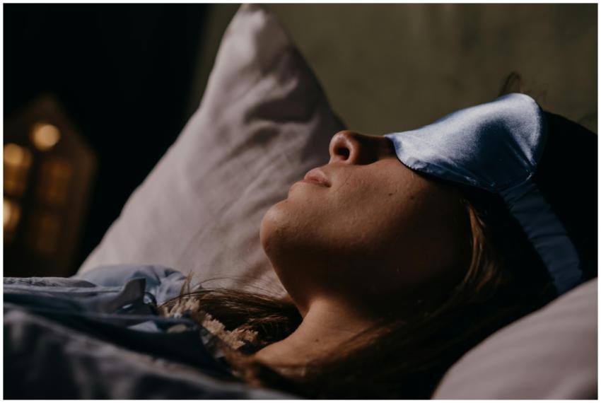 A serene scene of a woman wearing a blue eye mask,