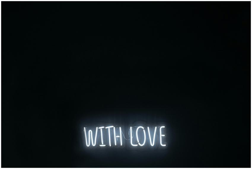 A minimalist neon sign glowing 'With Love' on a da