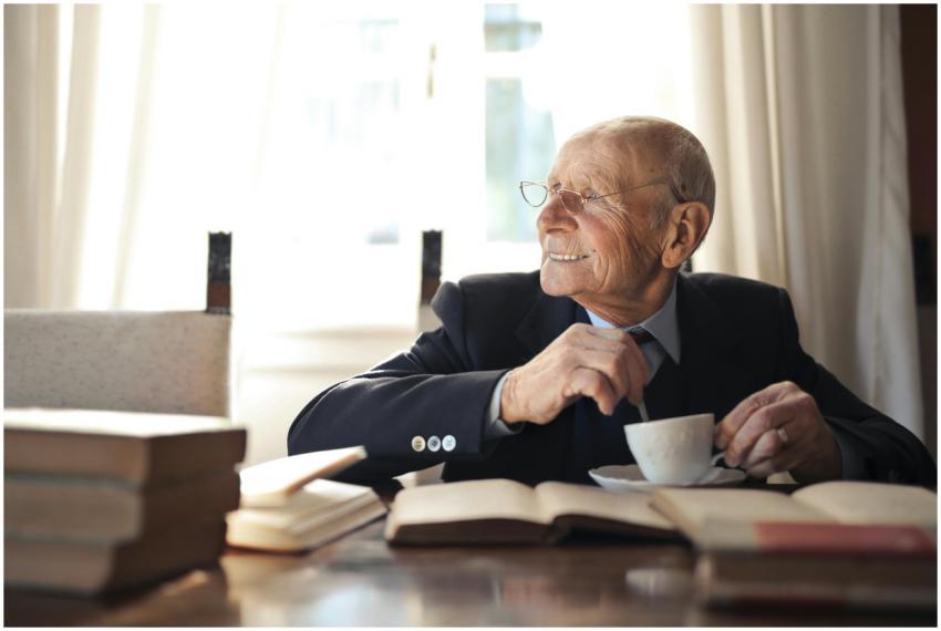 Positive senior man in formal suit and eyeglasses