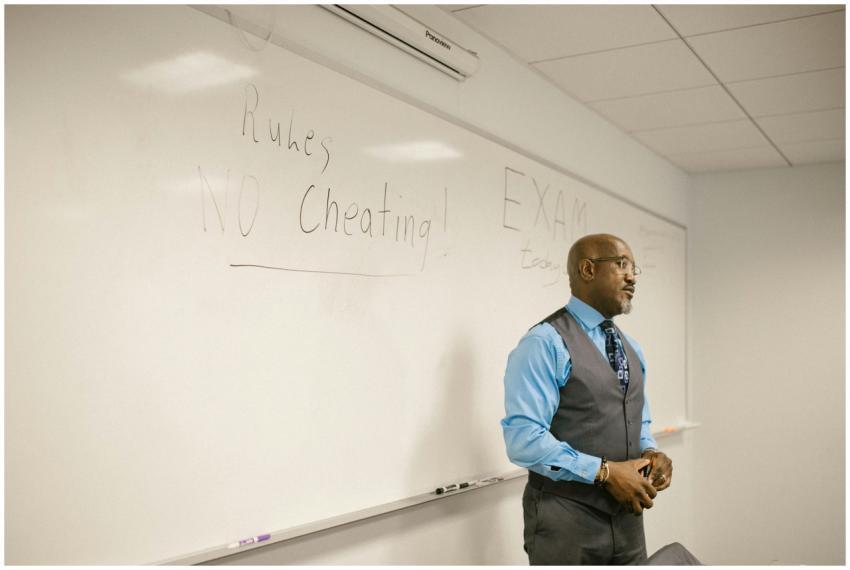 A professor in a classroom emphasizing exam rules