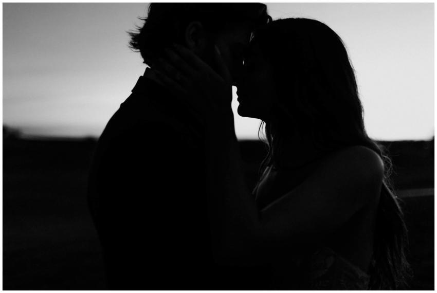Romantic silhouette of a couple kissing at twiligh
