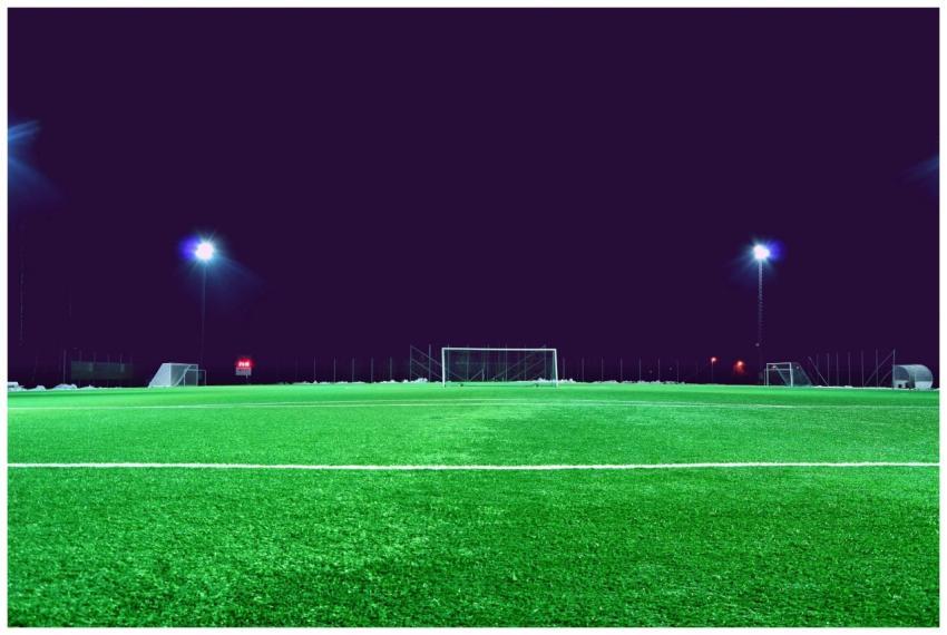 A brightly lit soccer field at night in Norrtälje,