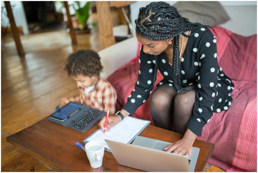 Mother multitasking with work and child at home, s