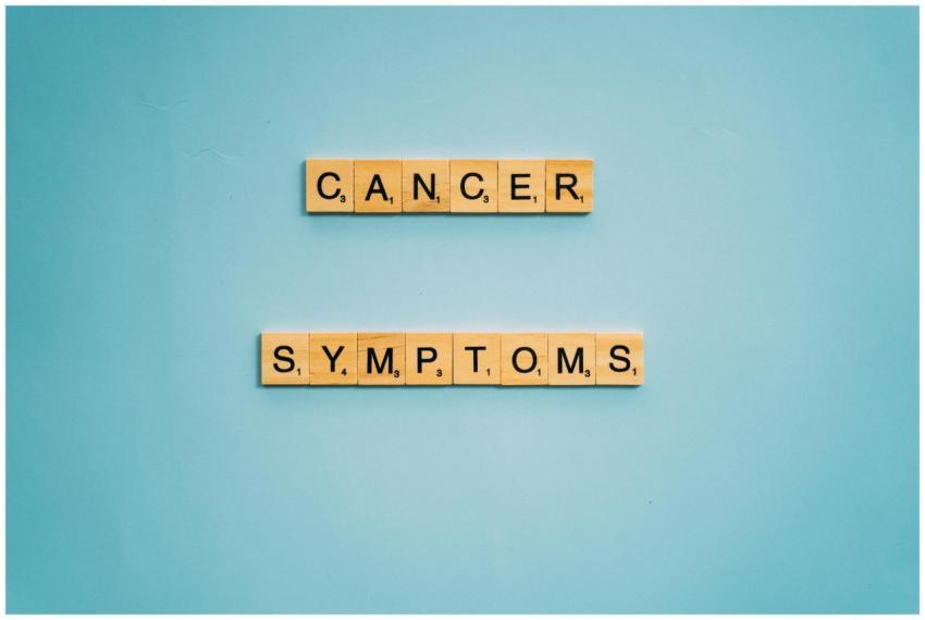 Scrabble tiles spelling 'Cancer Symptoms' on a lig