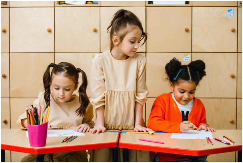 Three young girls enjoying drawing with colored pe