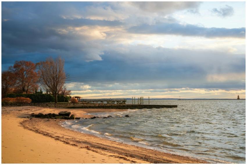 Beautiful beach scene with a pier and dramatic clo