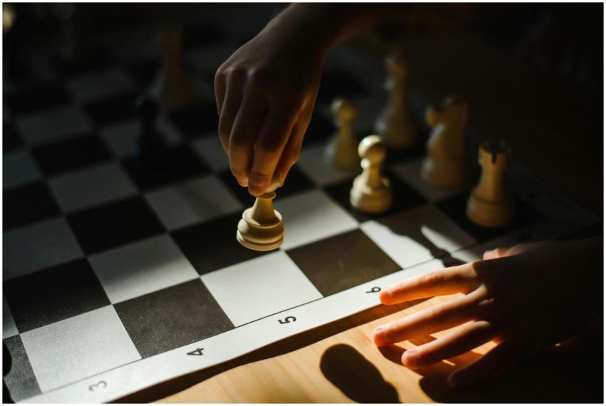Close-up of a child's hand making a strategic ches
