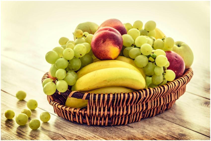 A colorful wicker basket filled with fresh grapes,