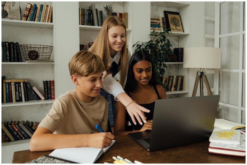 Group of teenagers studying together with a laptop