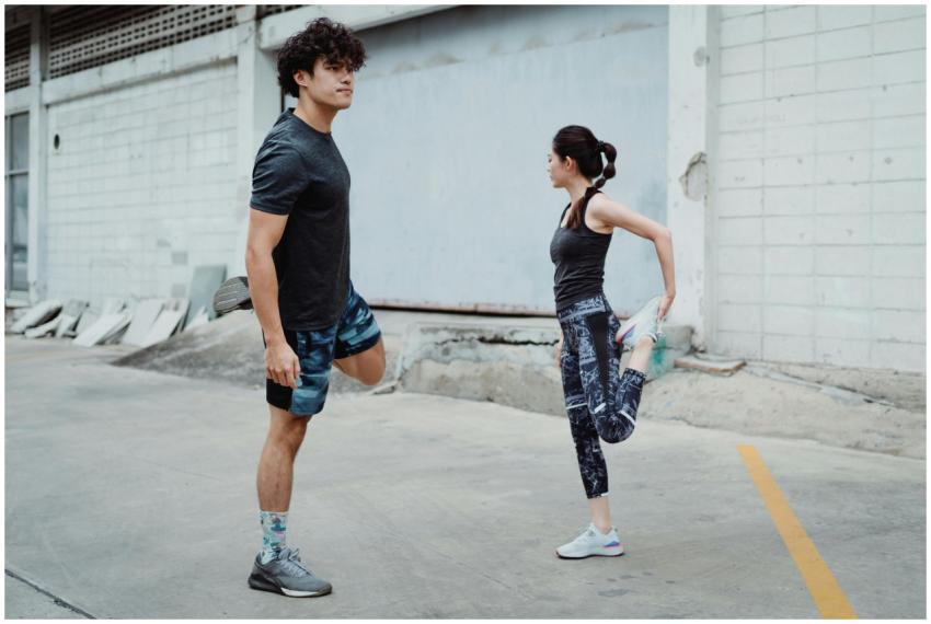 Two people stretching outdoors, focusing on balanc