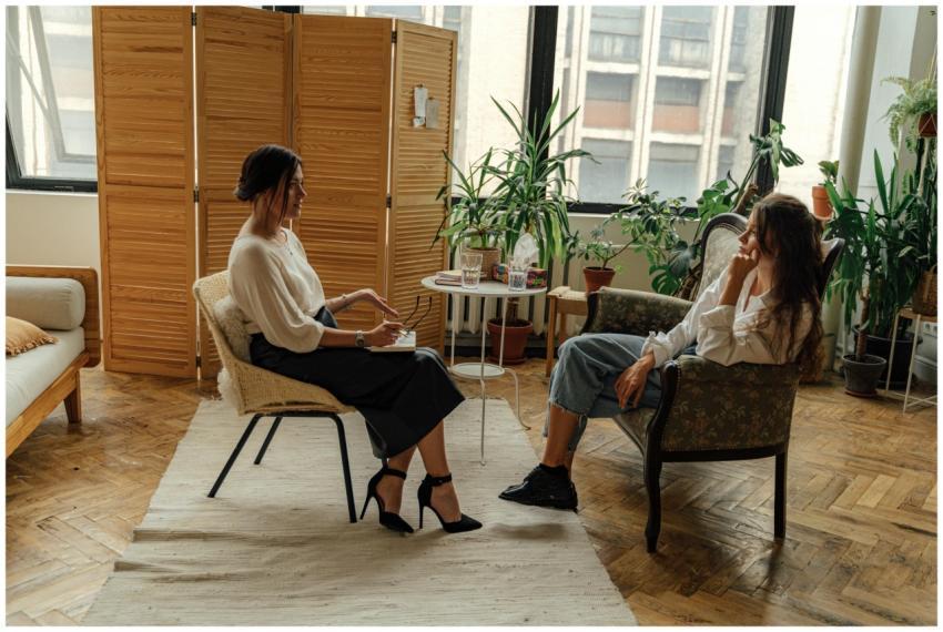 Two women sit in a therapy session, creating a tra