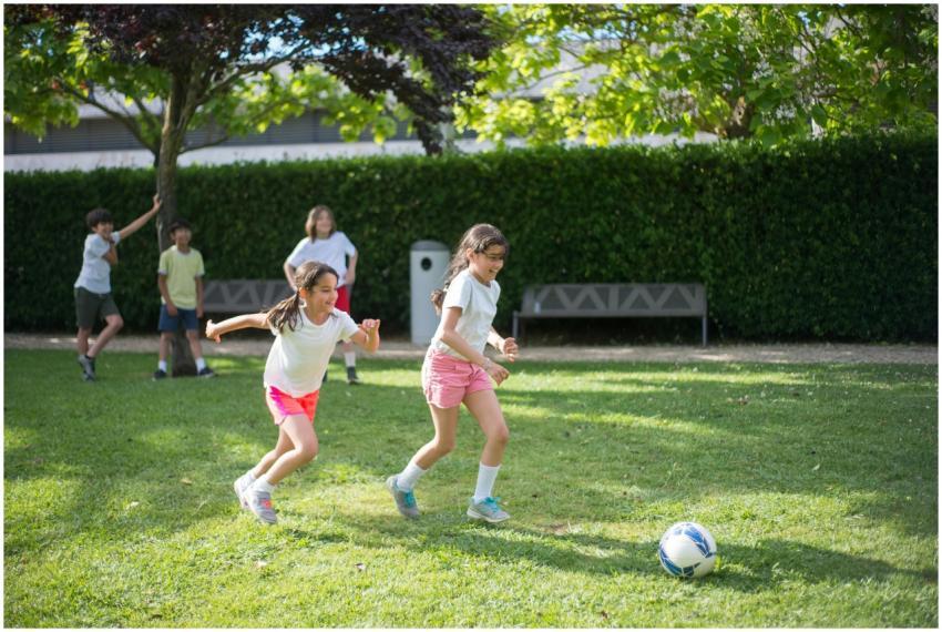 Children enjoy a game of soccer in a sunny park in