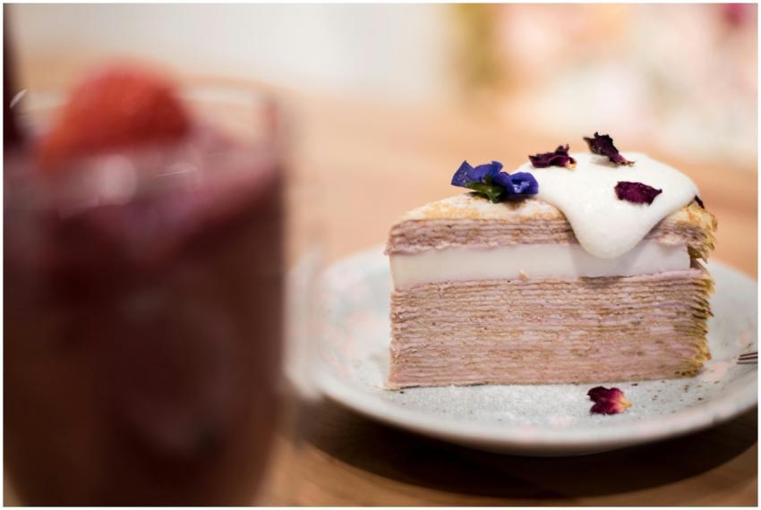 Slice of layered crepe cake with cream topping and
