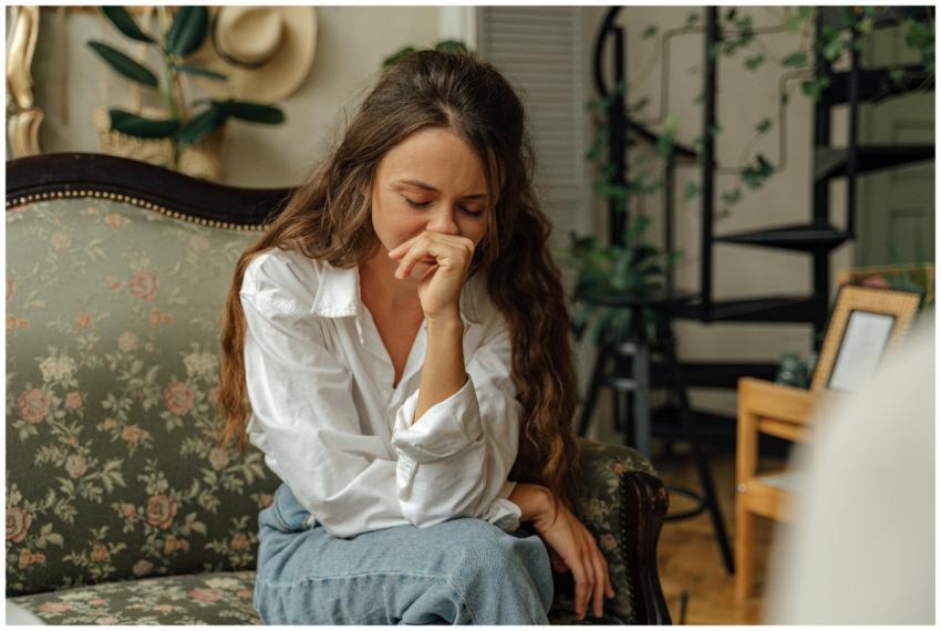 Woman in a white shirt sitting thoughtfully on a v
