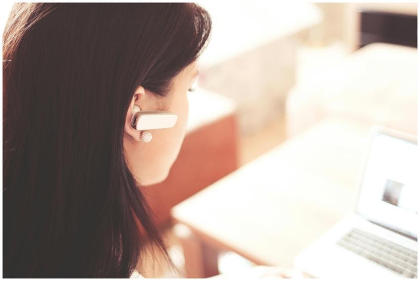 A businesswoman using a Bluetooth headset while wo