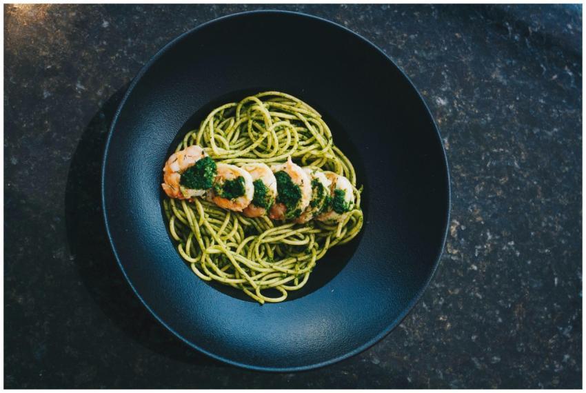 A vibrant overhead shot of shrimp pesto spaghetti