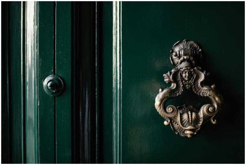 Close-up of a vintage brass knocker on a classic d