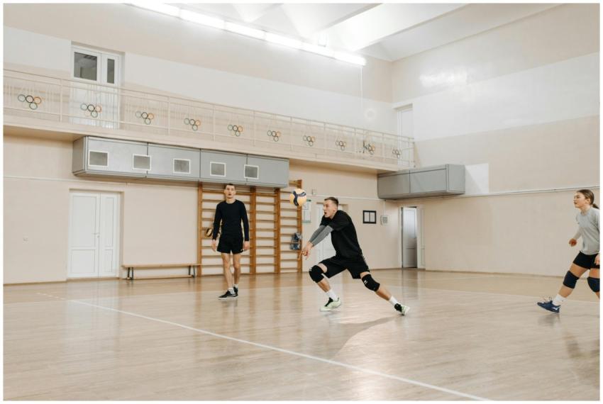 Team of athletes playing volleyball in an indoor c