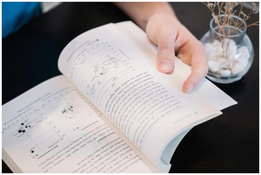 Close-up of a hand turning pages in a book with da