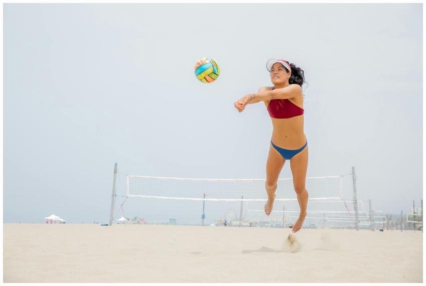 Athletic woman jumping midair during a beach volle