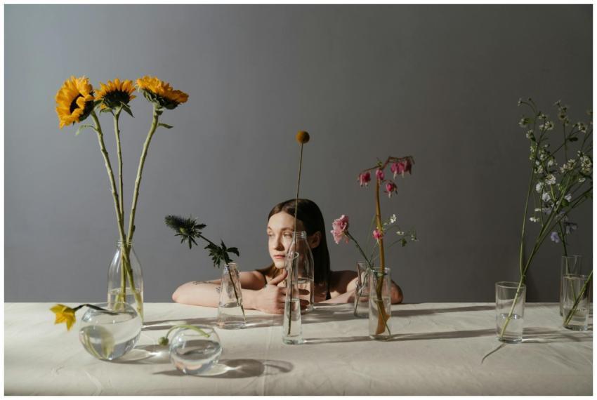 A creative floral display with a woman seated behi