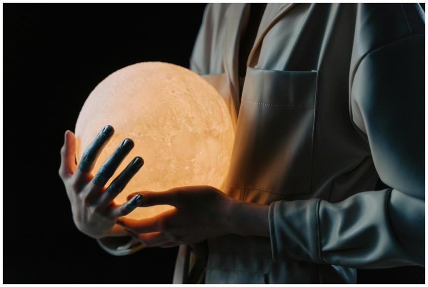 A person in a reflective pose holding a glowing sp