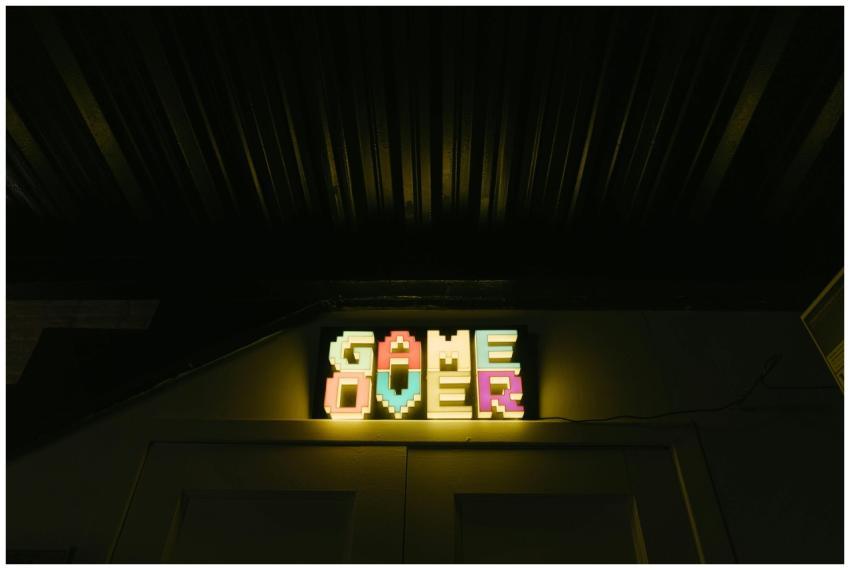 Glowing neon sign with pixelated Game Over text in