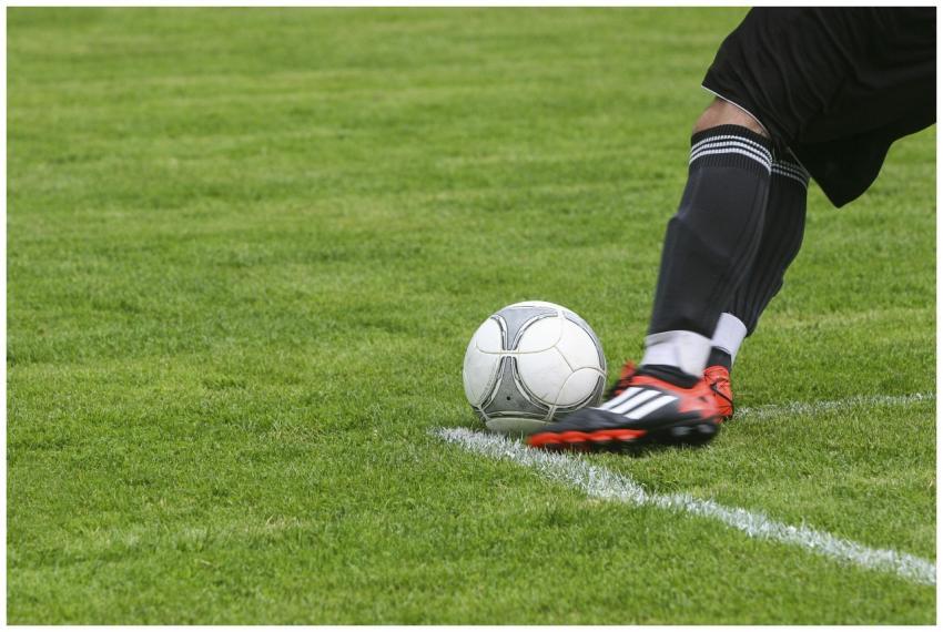 Dynamic shot of a soccer player kicking the ball o