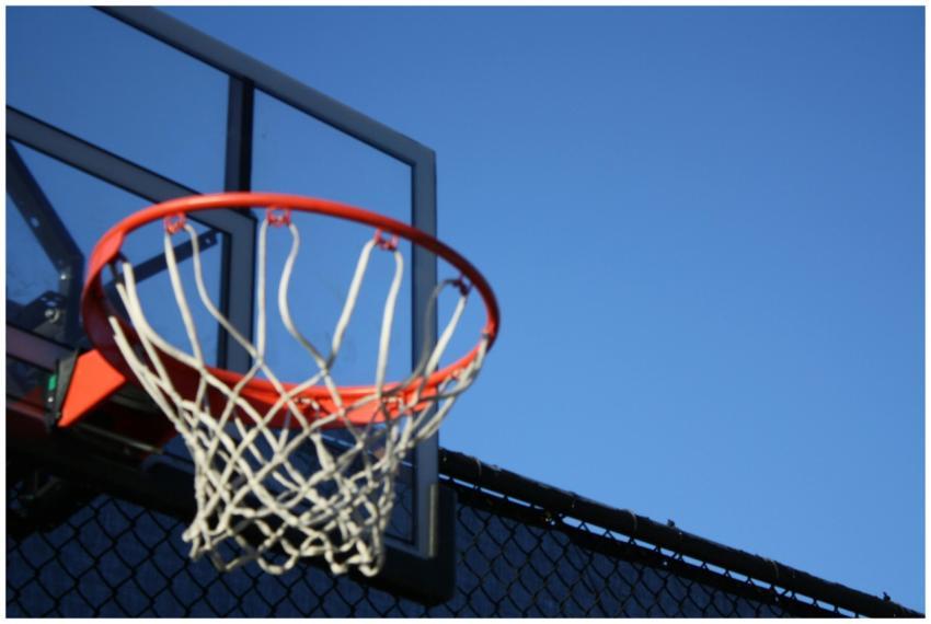 A vibrant outdoor basketball hoop with net set aga