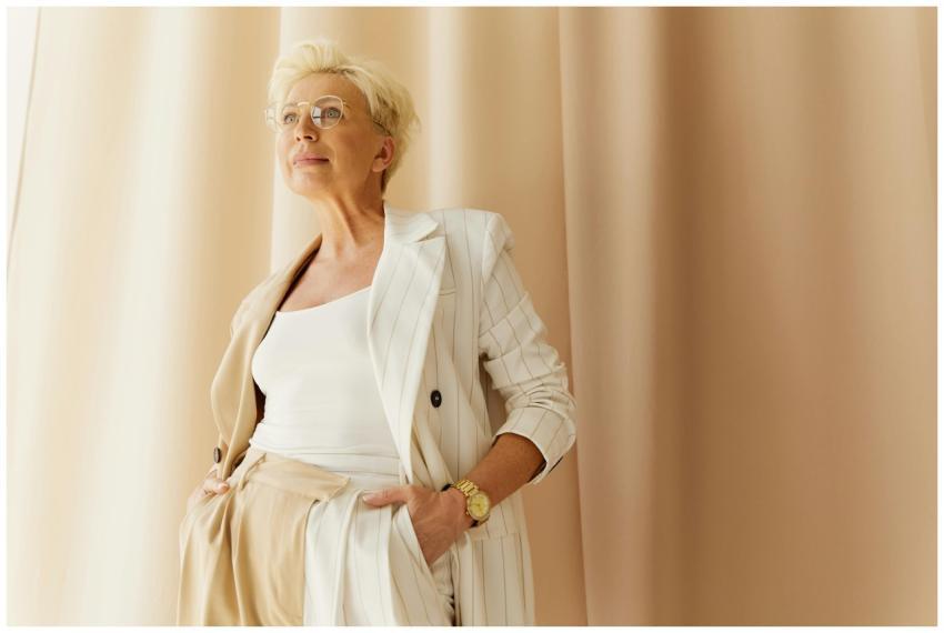 Elegant senior woman in a white pinstripe suit pos