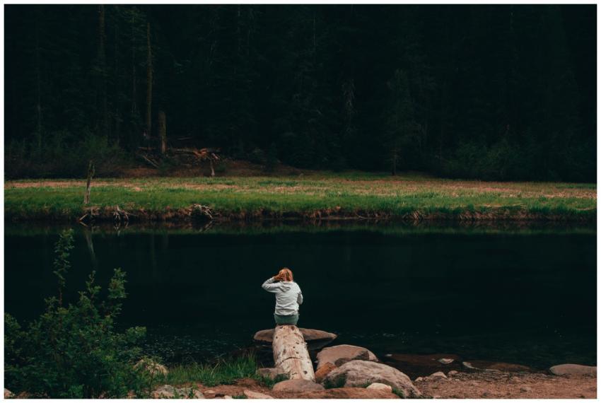 A woman enjoying solitude by a calm riverside in T