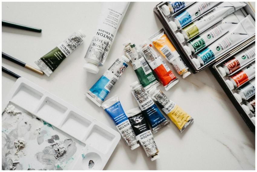 Top view of vibrant acrylic paint tubes and palett