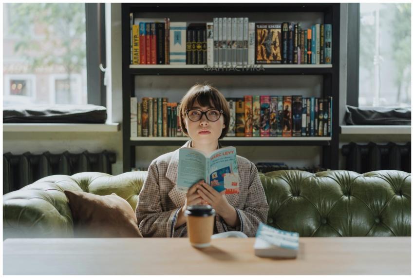 A young woman enjoys reading in a cozy library, ho