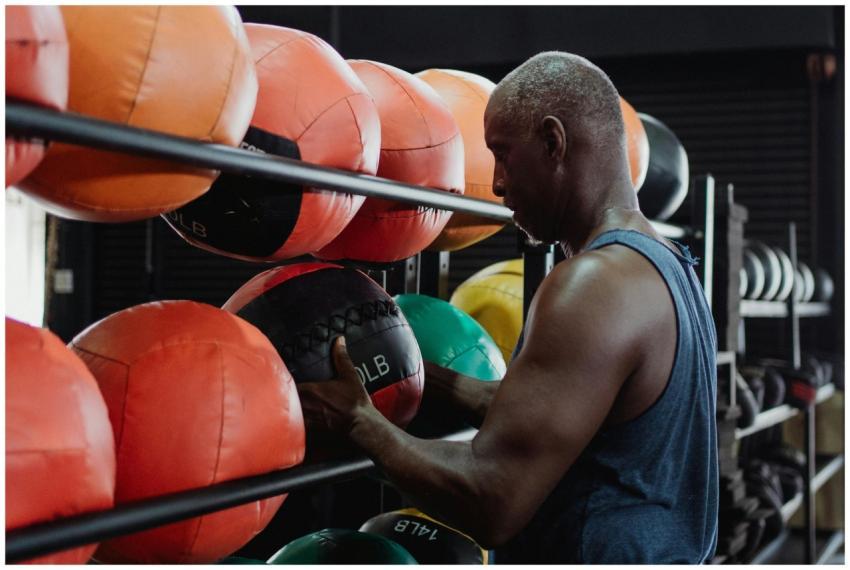 Athletic man choosing medicine ball for workout at
