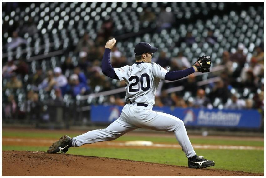 Baseball player pitching on field during a game, s