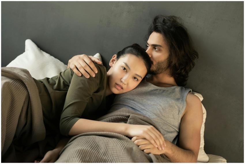 Romantic couple embracing on a bed, showcasing lov
