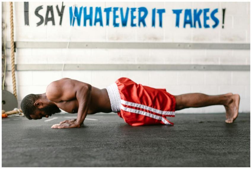 Athletic man doing push-ups indoors with motivatio