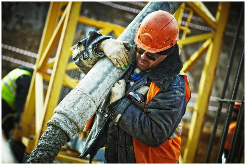Construction worker in safety gear handling equipm