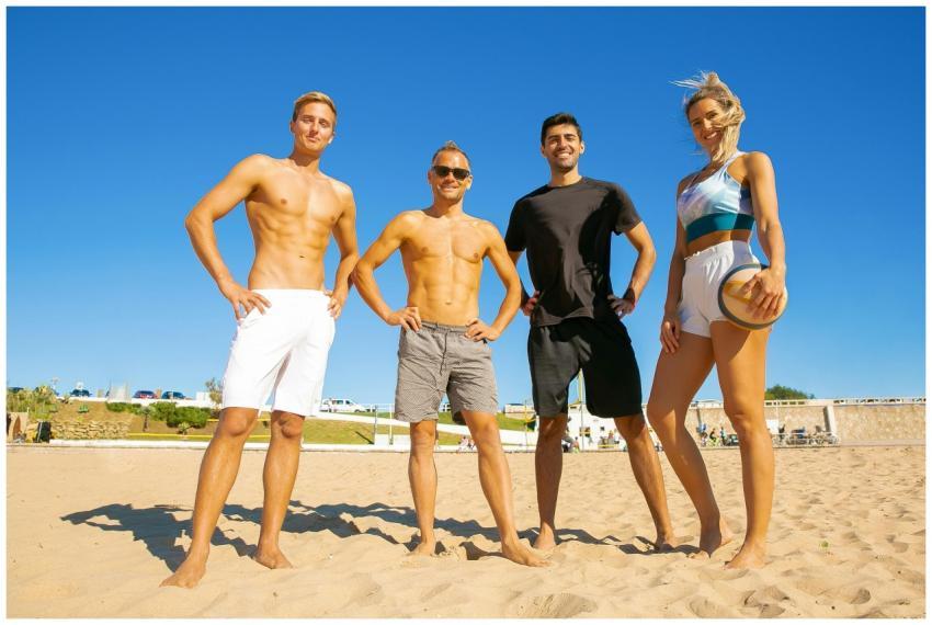 A group of adults posing confidently on a sunny be