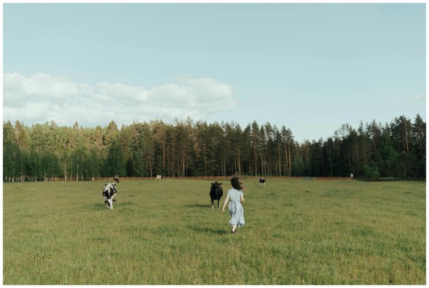 A young girl runs through a lush green meadow with