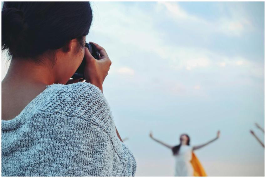 A female photographer takes a scenic outdoor photo
