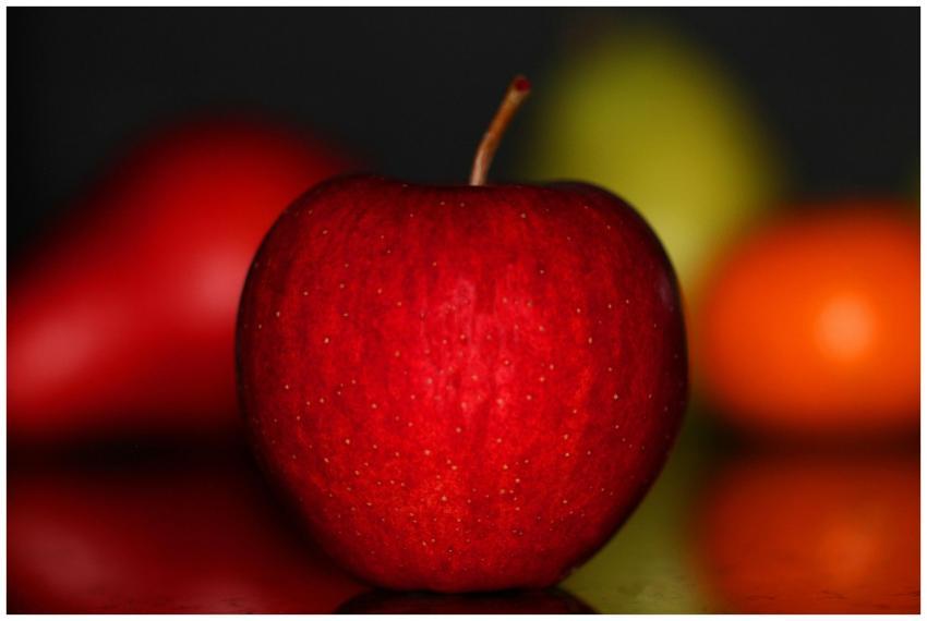 A crisp red apple with a glossy surface and soft b