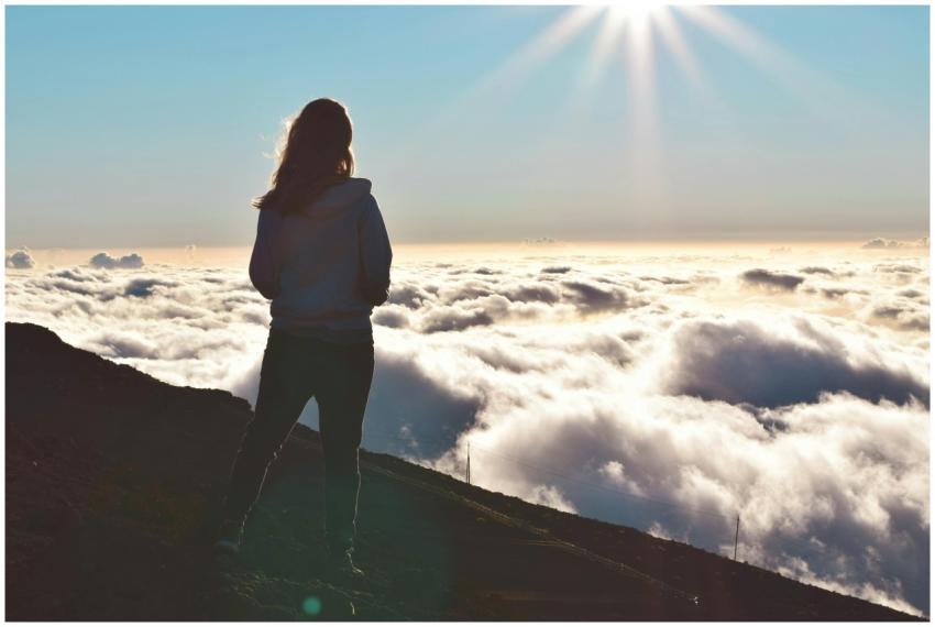 A silhouette of a person standing on a mountain ab