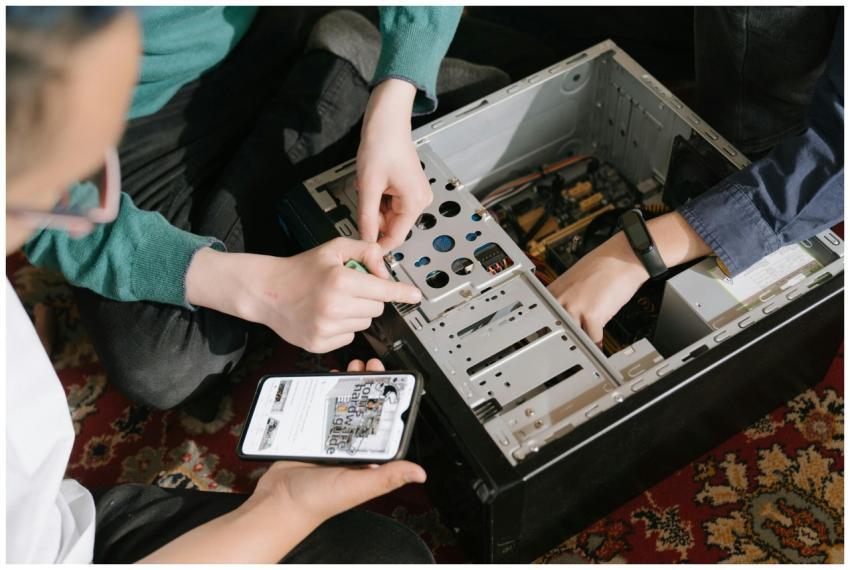 A close-up of hands fixing a computer with guidanc